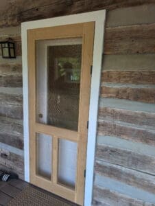 Custom wood screen door installed during a historic log home renovation in Middle Tennessee.